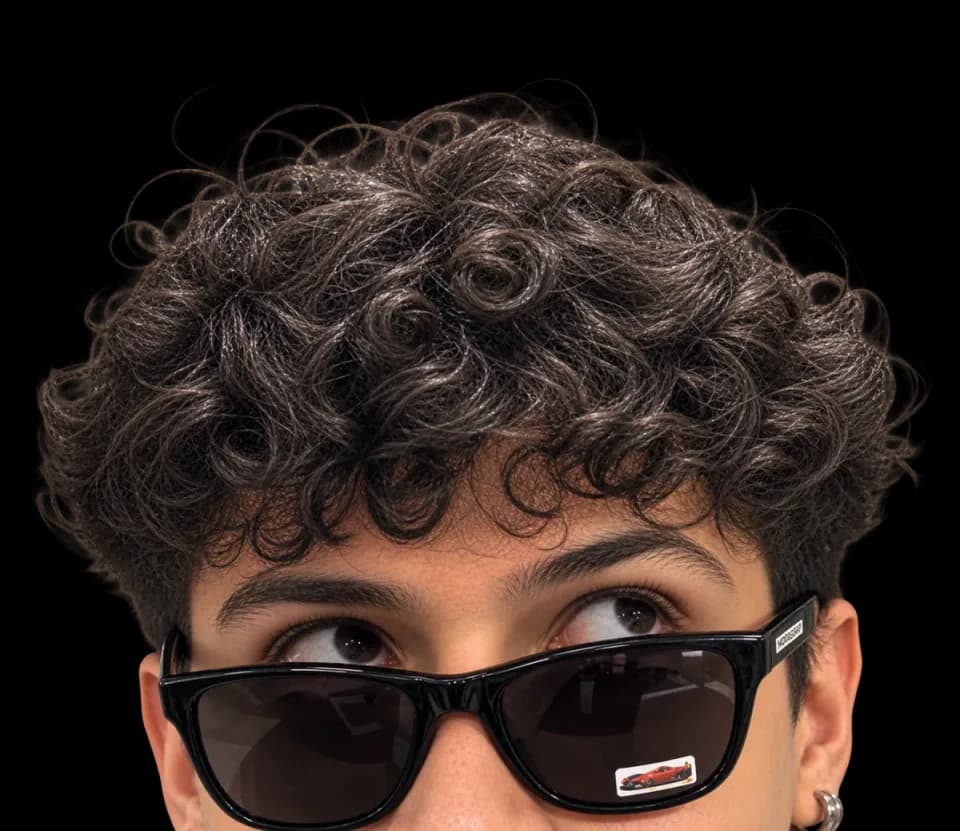 Joven con lentes de sol negros mirando hacia arriba con curiosidad